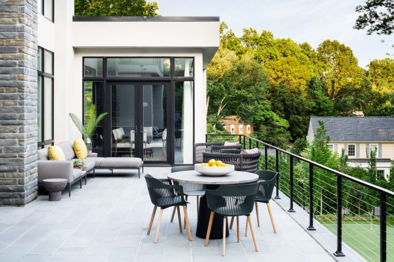 A curved drive, hornbeam hedge, allée of birches, and wildflower meadow together create privacy and lovely elements of surprise on the approach to this new house, which was designed for entertaining. Luxurious, but low-maintenance native and adaptive plantings are integrated into the overall landscape plan to balance the considerable hardscaping and define the lawns. At the front of the house, a massive parking court with subtly striped paving and an elegant retaining wall create a distinctive outdoor room. Guests have a variety of gathering spaces at the rear of the house that include upper and lower terraces for seating and dining, a putting green, and pool and pool deck. A large rain garden in the lower slope completes the program requirements by absorbing drainage and recharging the aquifer.