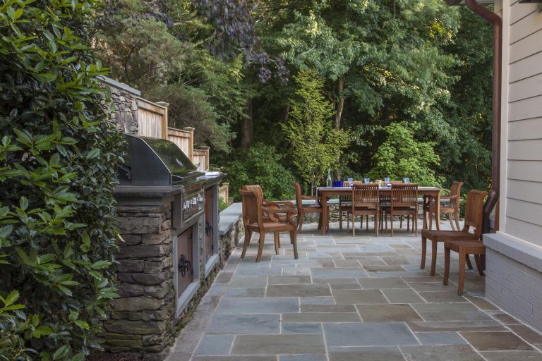 Guided by the client’s goal to solve the shortcomings of an aging, but topographically interesting and beautiful property, the resulting plan comprises four distinct entertaining spaces: A formal upper terrace with outdoor cooking, a dining space framed by a stone seat wall, a densely planted middle terrace with a fire pit, and finally a lower terrace designed for overflow seating and access to the kitchen garden. The entire site overlooks a wooded area and scenic creek. Complemented by Pennsylvania flagstone, plant material includes several varieties of hydrangeas (Hydrangea quercifolia, Hydrangea arborescens ‘Annabelle’), hydrangea macrophylla ‘Endless summer’). Oak Leaf Hollies (Ilex x “Conaf”) and cedar fencing help screen the neighboring property while perennials offer bright accents between the low shrubbery. The joints between pavers and boulders are softened with mazus (Mazus reptans), Blue-Star Creeper (Isotoma fluviatilis), Walker’s Low Catmint (Nepeta x faassenii ‘Walker’s Low’),and rosemary (Rosmarinus officinalis). The hillside serves as a respite, providing the owners a place to unwind and enjoy their garden.