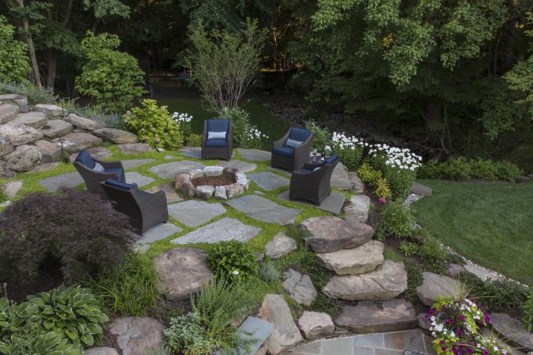 Guided by the client’s goal to solve the shortcomings of an aging, but topographically interesting and beautiful property, the resulting plan comprises four distinct entertaining spaces: A formal upper terrace with outdoor cooking, a dining space framed by a stone seat wall, a densely planted middle terrace with a fire pit, and finally a lower terrace designed for overflow seating and access to the kitchen garden. The entire site overlooks a wooded area and scenic creek. Complemented by Pennsylvania flagstone, plant material includes several varieties of hydrangeas (Hydrangea quercifolia, Hydrangea arborescens ‘Annabelle’), hydrangea macrophylla ‘Endless summer’). Oak Leaf Hollies (Ilex x “Conaf”) and cedar fencing help screen the neighboring property while perennials offer bright accents between the low shrubbery. The joints between pavers and boulders are softened with mazus (Mazus reptans), Blue-Star Creeper (Isotoma fluviatilis), Walker’s Low Catmint (Nepeta x faassenii ‘Walker’s Low’),and rosemary (Rosmarinus officinalis). The hillside serves as a respite, providing the owners a place to unwind and enjoy their garden.