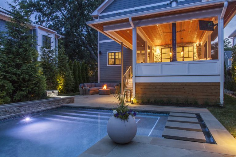 The program for this 2,500-square-foot rear yard neatly addresses a compact area and the client’s requirements for entertaining. A small cocktail pool, lounge area, and screened-in porch with a cantilevered roof unify the outdoor space and offer variety and flexibility. Highly designed components and materials, such as the fire pit in the lounge, floating stepping-stones in the pool, and bluestone pavers in subtle patterns provide interest. Two separate water features are visually captivating and also provide a sound buffer from neighboring properties. The porch is large enough to seat six and a Malm style gas fireplace makes it an enticing room during the colder months. Privacy is achieved with lush plantings of hornbeam, arborvitae, and maples. A secondary layer of flowering shrubs, ornamental grasses, and perennials are planted in patterns to mimic the geometry of the pool and surrounding hardscaping.