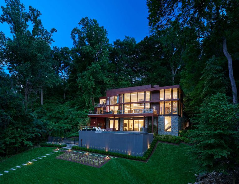 Front exterior view of Landscape Architect DC’s modern house on the Potomac River at night.
