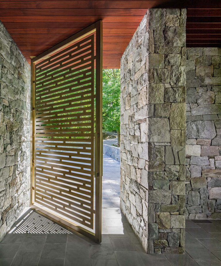 The masterplan for this unique property — a steeply sloping three-acre site and riverfront clearing — included stabilizing eroded creeks, restoring wetlands, and incorporating a massive rain garden to filter storm water flow from the parking court above and other properties further up the hill. The owners, a family with four dogs, also had requirements that included adequate parking for entertaining, a dedicated recreation space for the dogs, and a beautifully blended network of new plantings, hardscape, and sculpture to be seen from and complement the linear forms of their organic-modern home in the woods.