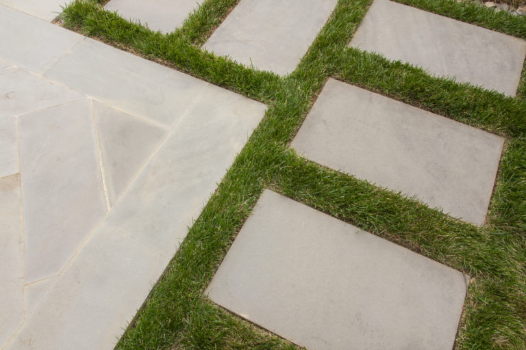 The program for this 2,500-square-foot rear yard neatly addresses a compact area and the client’s requirements for entertaining. A small cocktail pool, lounge area, and screened-in porch with a cantilevered roof unify the outdoor space and offer variety and flexibility. Highly designed components and materials, such as the fire pit in the lounge, floating stepping-stones in the pool, and bluestone pavers in subtle patterns provide interest. Two separate water features are visually captivating and also provide a sound buffer from neighboring properties. The porch is large enough to seat six and a Malm style gas fireplace makes it an enticing room during the colder months. Privacy is achieved with lush plantings of hornbeam, arborvitae, and maples. A secondary layer of flowering shrubs, ornamental grasses, and perennials are planted in patterns to mimic the geometry of the pool and surrounding hardscaping.